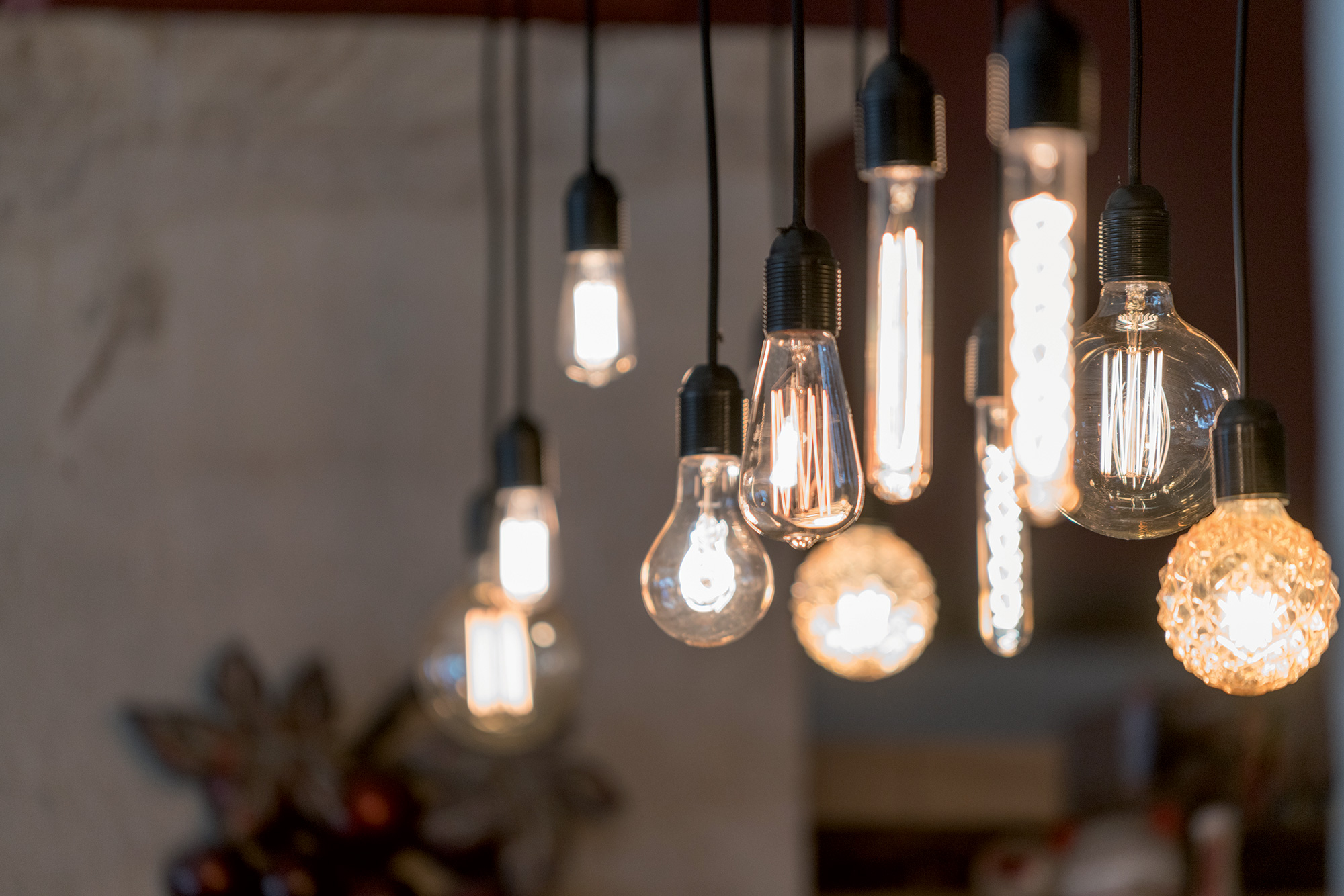 Plusieurs ampoules design et tendance sont suspendues ensemble pour créer un luminaire pour la maison.