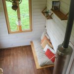 Intérieur d'une tiny house. Fenêtre bois aluminium Minco dans un salon.