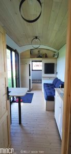 Vue d'ensemble intérieur d'une tiny house. Fenêtre et porte-fenêtre bois aluminium Minco.